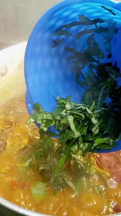 Step 1.3: Add a few slices of uziza leaves and stir properly