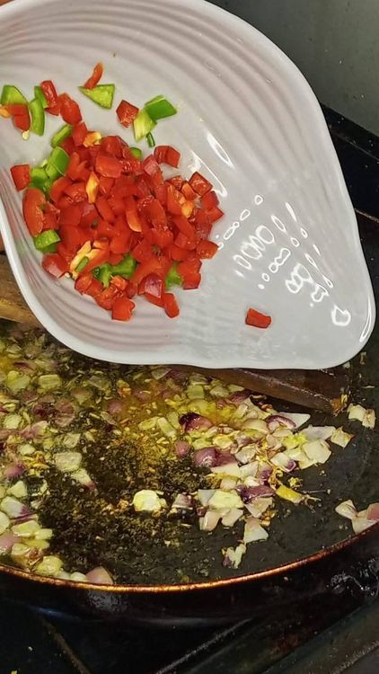 Step 2.3: Add the seasoning cube, stir, and then add the chopped bell peppers and spring onions