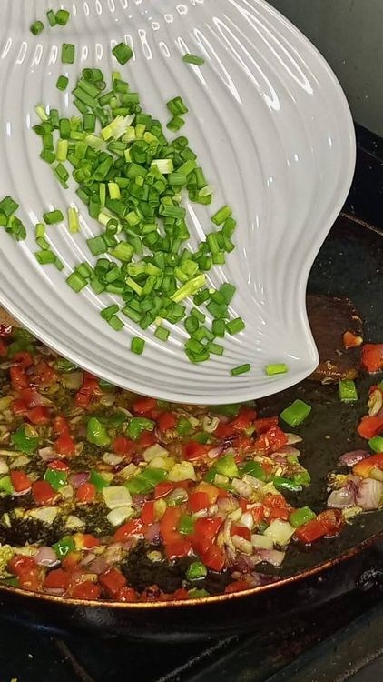 Step 2.1: Add the seasoning cube, stir, and then add the chopped bell peppers and spring onions