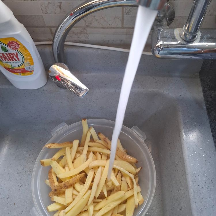 Step 1.1: Place the sliced potatoes into a bowl, wash them properly, and drain the water