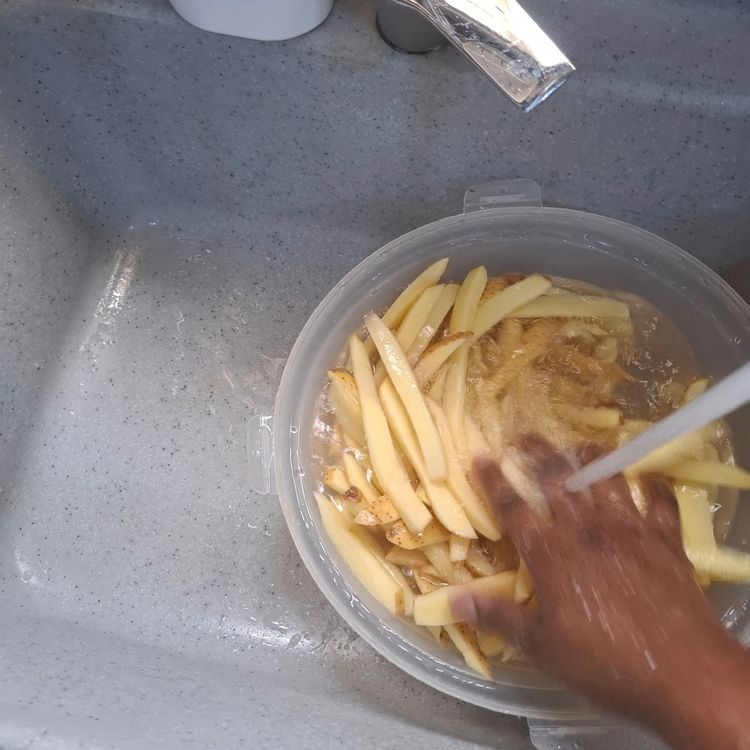 Step 1.2: Place the sliced potatoes into a bowl, wash them properly, and drain the water