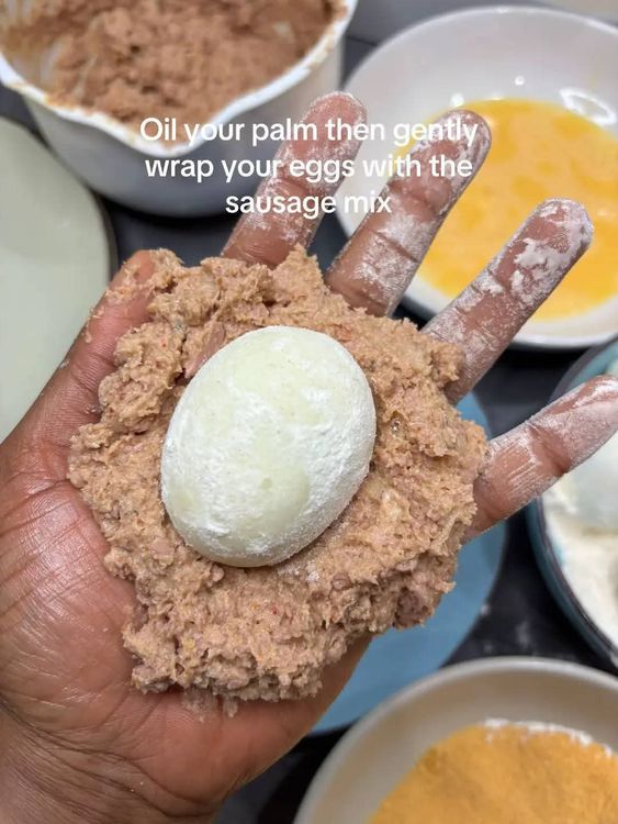 Step 3.1: Oil your palm, then gently wrap the eggs with the sausage mix