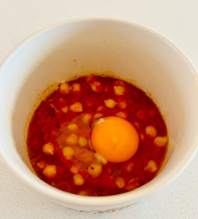 Step 1.1: Make a well in the center of the sauce and crack the egg into the well