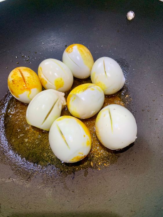 Step 2.1: Roll the boiled eggs in the spices on low heat until lightly golden and coated