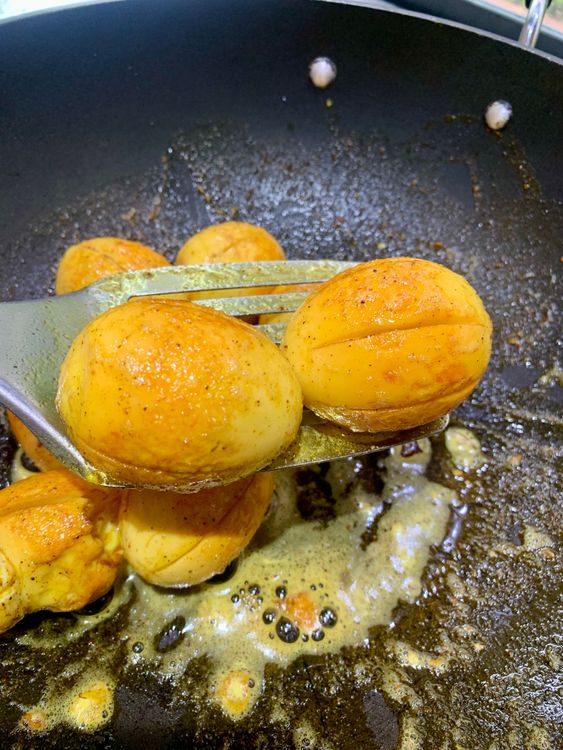 Step 2.2: Roll the boiled eggs in the spices on low heat until lightly golden and coated