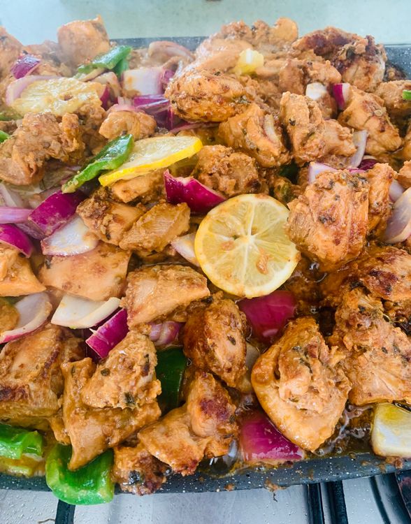 Step 3.1: Add the capsicum, onion cubes and lemon rounds to the tawa when the chicken is mostly done