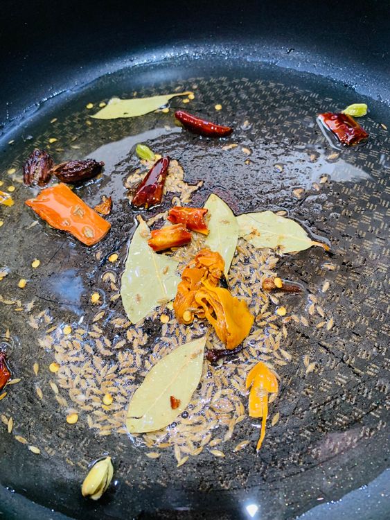 Step 2.1: Add bay leaves, cinnamon, cloves, black cardamoms, green cardamoms, dry red chillies, mace, and cumin seeds