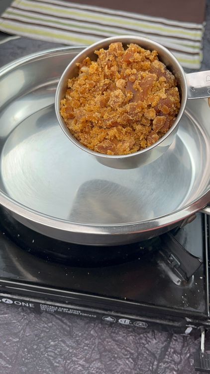Step 7.1: In a large pan, add grated jaggery and water
