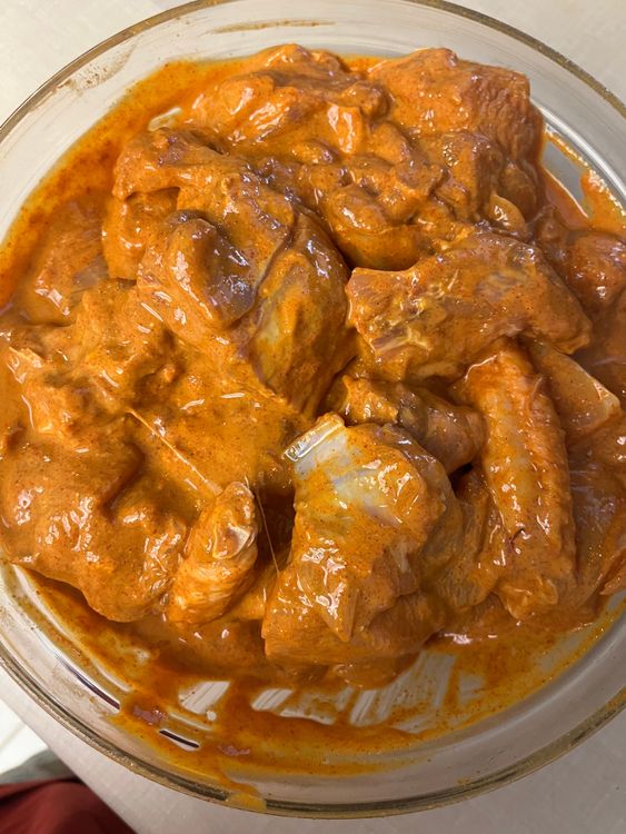 Step 1.4: Transfer the chicken pieces to a mixing bowl and add salt, red chilli powder, coriander powder, cumin powder, and thick curd