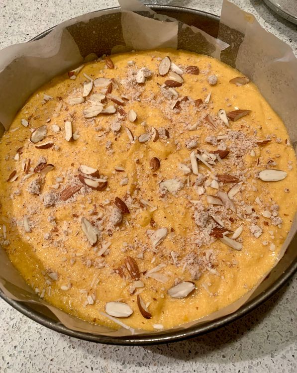 Step 1.1: Pour the batter into the prepared cake tin and decorate the top with sliced almonds