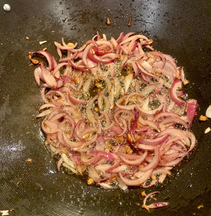 Step 2.1: Add the sliced onions to the wok and cook until they turn translucent