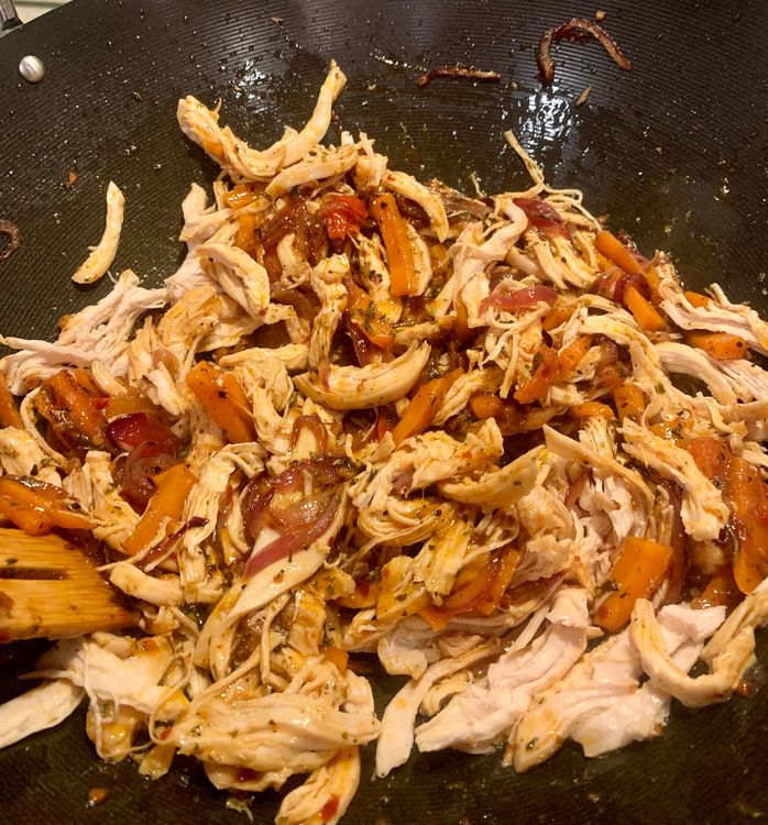 Step 2.2: Add the shredded chicken to the wok, stirring and cooking for a few minutes