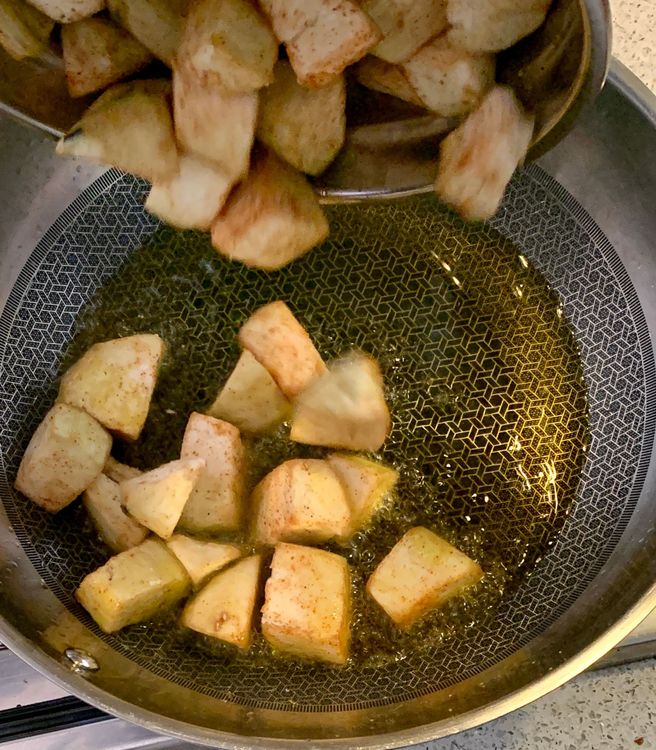 Step 1.1: Add the cubed eggplants to the wok and sauté them until they turn slightly golden