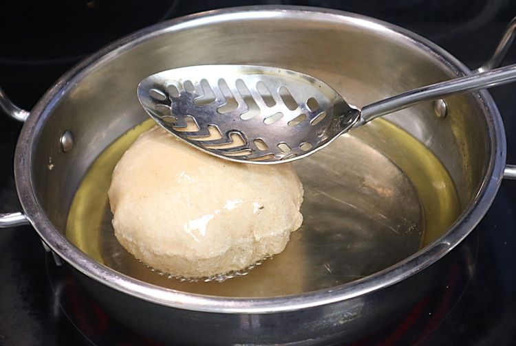 Step 1.2: Press until the poori puffs up and splash oil to puff up fully