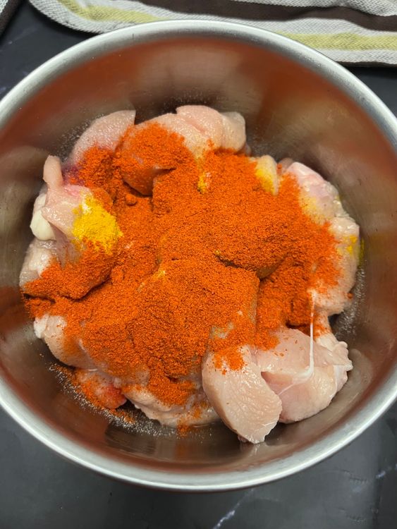 Step 1.1: Add salt, turmeric, red chilli powder, ginger-garlic paste, and squeeze in half a lemon