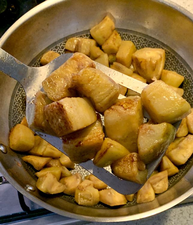 Step 1.2: Add the cubed eggplants to the wok and sauté them until they turn slightly golden
