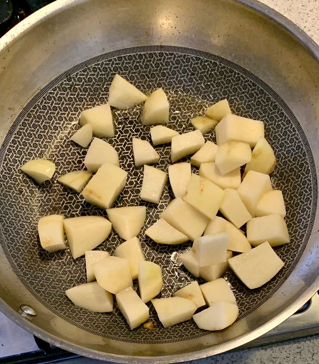 Step 1.1: In the same wok, add 1 tbsp of oil and saute the cubed potatoes until they become golden on the edges