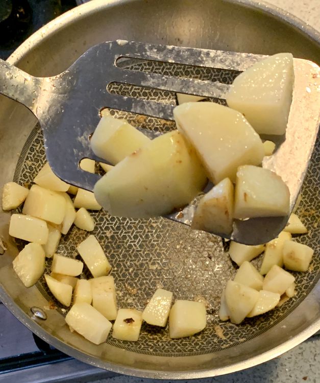 Step 1.2: In the same wok, add 1 tbsp of oil and saute the cubed potatoes until they become golden on the edges