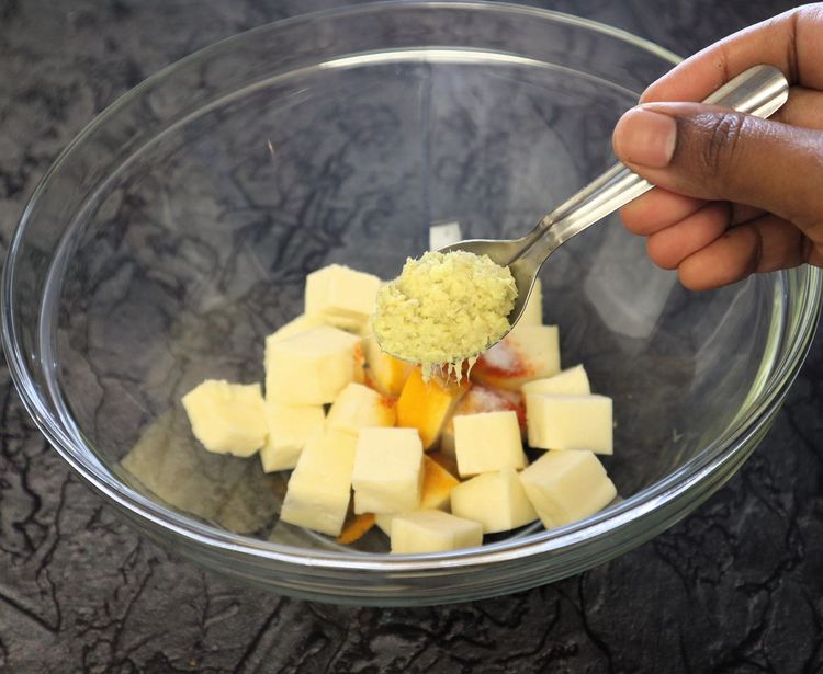 Step 1.8: In a large bowl, take paneer cubes, turmeric, chilli powder, ginger garlic paste, and salt