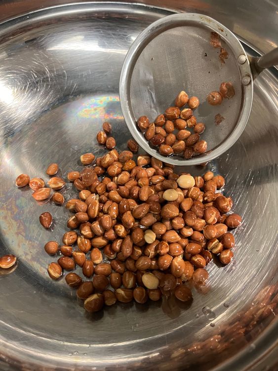 Step 2.4: In a deep kadai, heat oil and fry the peanuts until the skin separates