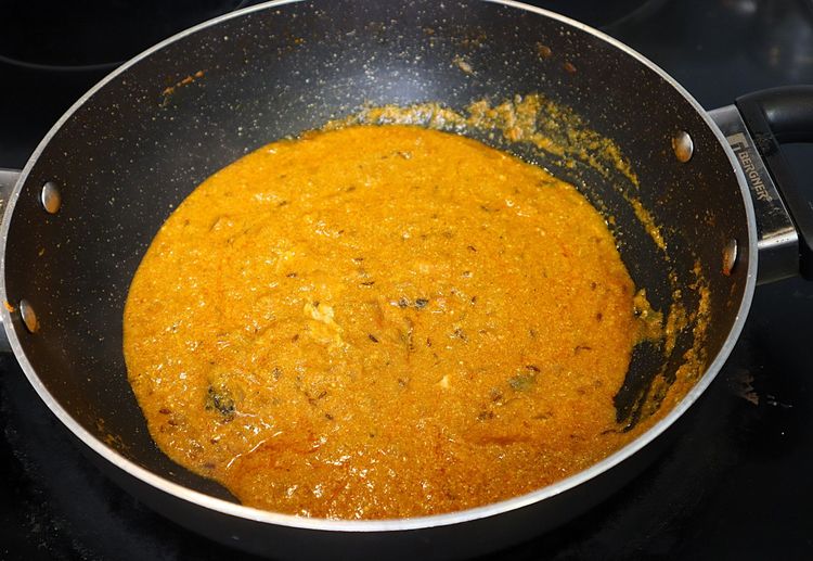 Step 2.2: Keeping the flame on low, add curd and stir continuously