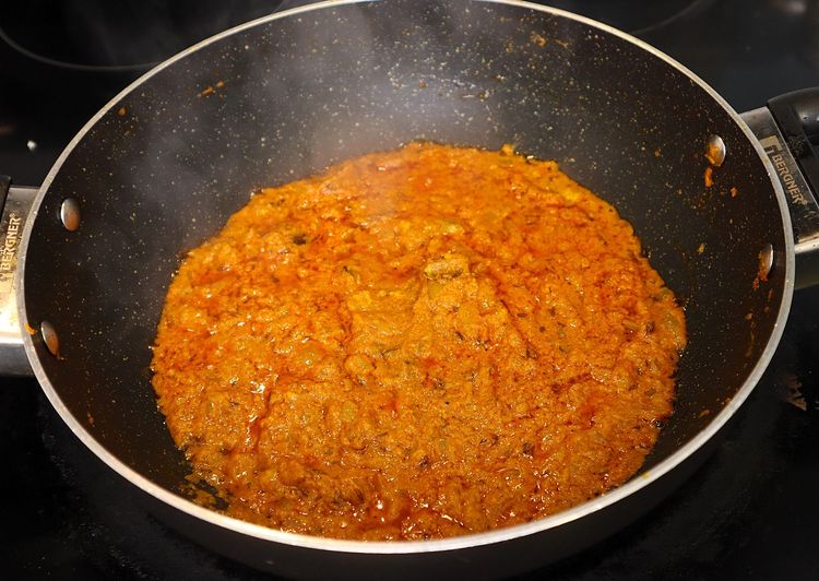 Step 2.4: Keeping the flame on low, add curd and stir continuously