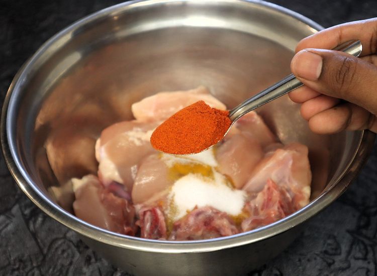 Step 1.4: Marinate the chicken with turmeric powder, salt, red chili powder, and oil