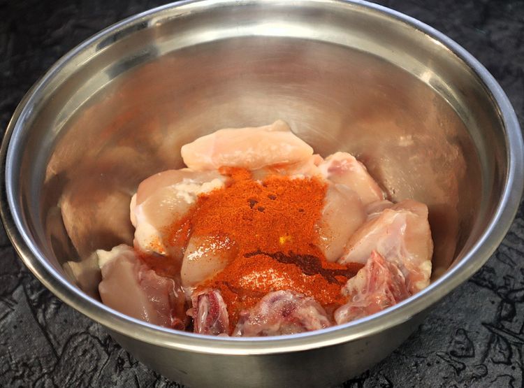 Step 1.6: Marinate the chicken with turmeric powder, salt, red chili powder, and oil