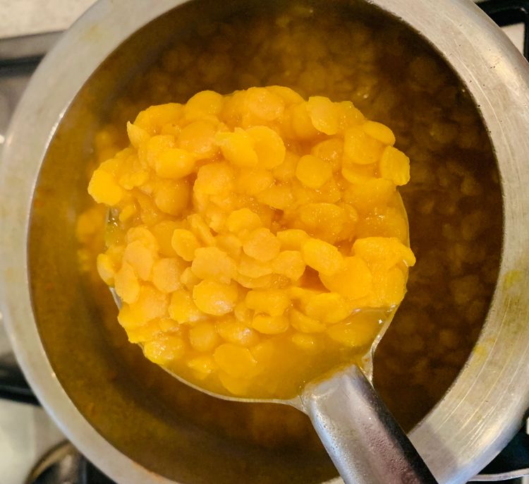 Step 1.2: Close the lid of the pressure cooker and cook the dal on medium heat for 1-2 whistles or until the dal is soft and cooked through