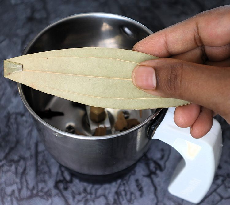 Step 2.6: In a mixer jar, blend cinnamon stick, cloves, green cardamom, star anise, bay leaf, cumin seeds, coriander seeds, black pepper, whole cashews, and poppy seeds into a fine powder