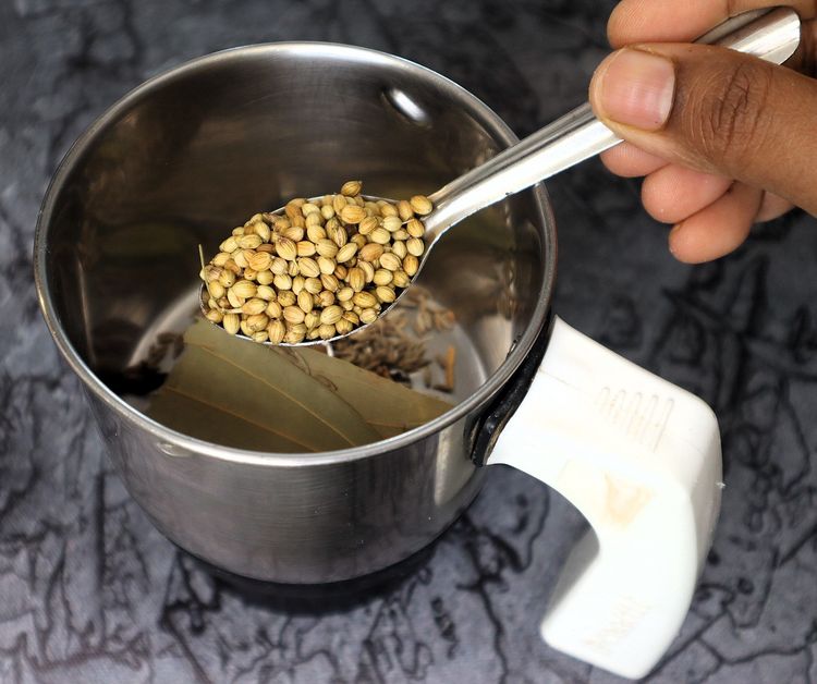 Step 2.8: In a mixer jar, blend cinnamon stick, cloves, green cardamom, star anise, bay leaf, cumin seeds, coriander seeds, black pepper, whole cashews, and poppy seeds into a fine powder