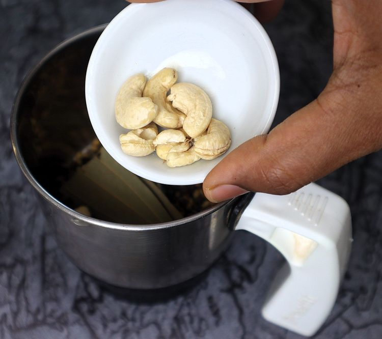 Step 2.10: In a mixer jar, blend cinnamon stick, cloves, green cardamom, star anise, bay leaf, cumin seeds, coriander seeds, black pepper, whole cashews, and poppy seeds into a fine powder