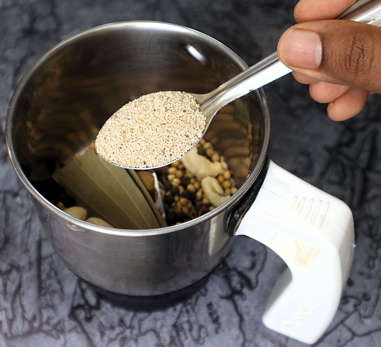 Step 2.11: In a mixer jar, blend cinnamon stick, cloves, green cardamom, star anise, bay leaf, cumin seeds, coriander seeds, black pepper, whole cashews, and poppy seeds into a fine powder