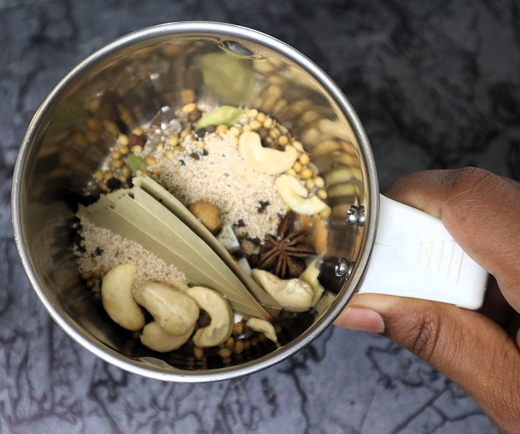 Step 2.12: In a mixer jar, blend cinnamon stick, cloves, green cardamom, star anise, bay leaf, cumin seeds, coriander seeds, black pepper, whole cashews, and poppy seeds into a fine powder
