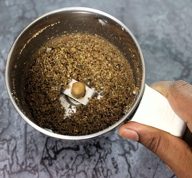 Step 2.13: In a mixer jar, blend cinnamon stick, cloves, green cardamom, star anise, bay leaf, cumin seeds, coriander seeds, black pepper, whole cashews, and poppy seeds into a fine powder
