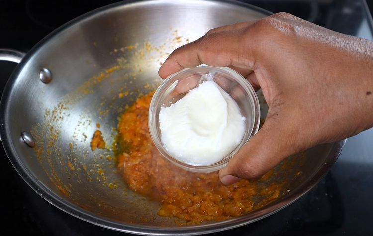 Step 3.1: Add curd and fry on low flame until it incorporates into the oil