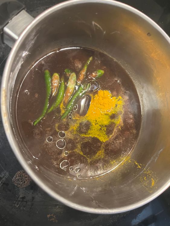 Step 5.1: In a small pan, add tamarind extract, salt, turmeric, oil, and slit green chillies