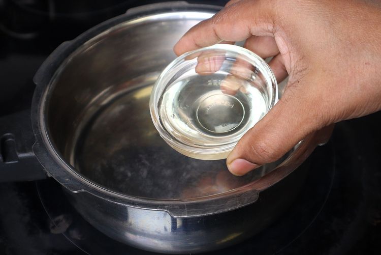 Step 1.2: In a pressure cooker, heat oil over medium to low flame