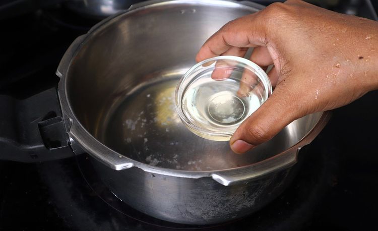 Step 1.2: In a heavy-bottom vessel or cooker, heat oil over medium to low flame