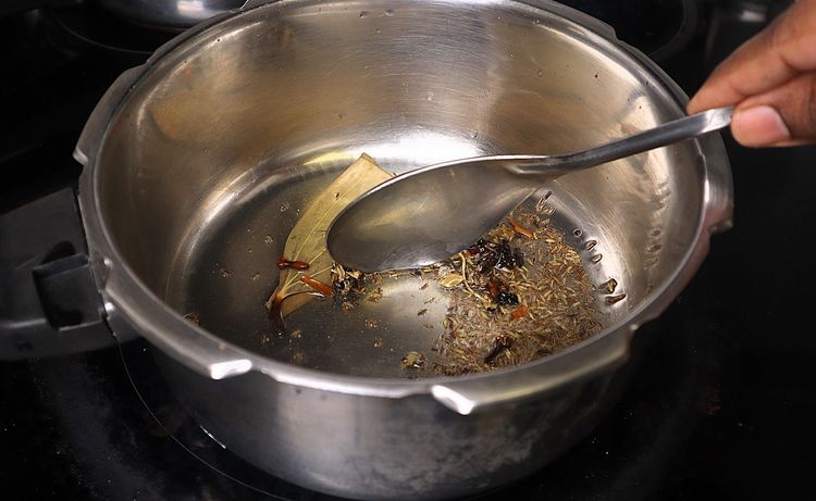 Step 1.5: Once the oil is hot, add bay leaf, cinnamon stick, cloves, stone flower, marati mogga, star anise, and shajeera
