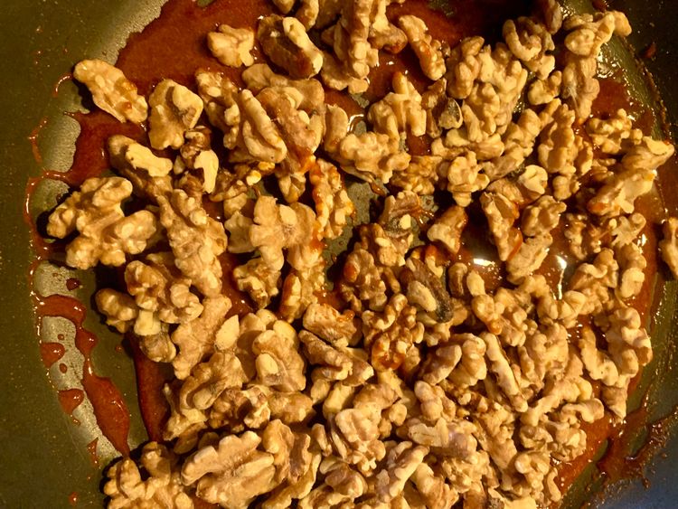 Step 1.1: Add the roasted walnuts to the pan with the melted jaggery
