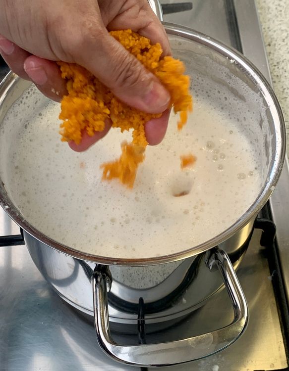 Step 1.1: Add the crushed ladoos to the pan and continue stirring to prevent burning