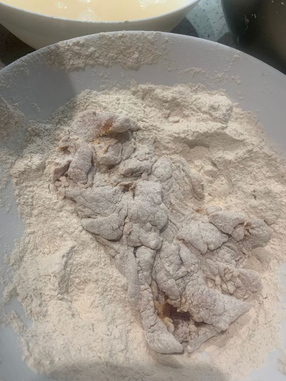 Step 2.2: Coat each marinated chicken fillet with the flour mix, tossing it a few times to ensure an even coating