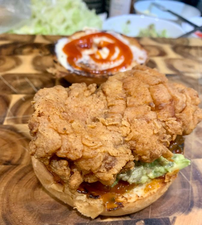 Step 4.1: Stack the burger bun with tomato sauce, avocado mix, fried chicken fillets, tomato slice, cheese slice and shredded lettuce