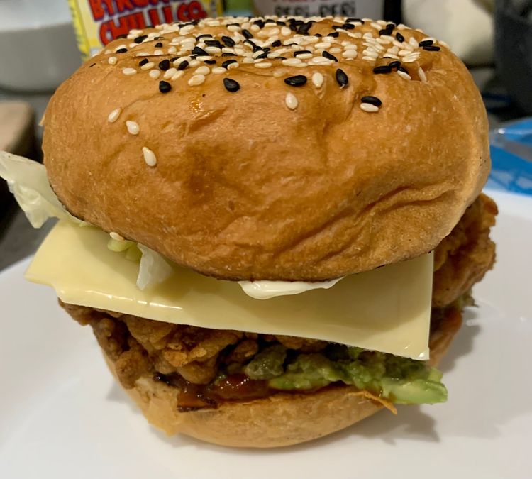 Step 4.4: Stack the burger bun with tomato sauce, avocado mix, fried chicken fillets, tomato slice, cheese slice and shredded lettuce