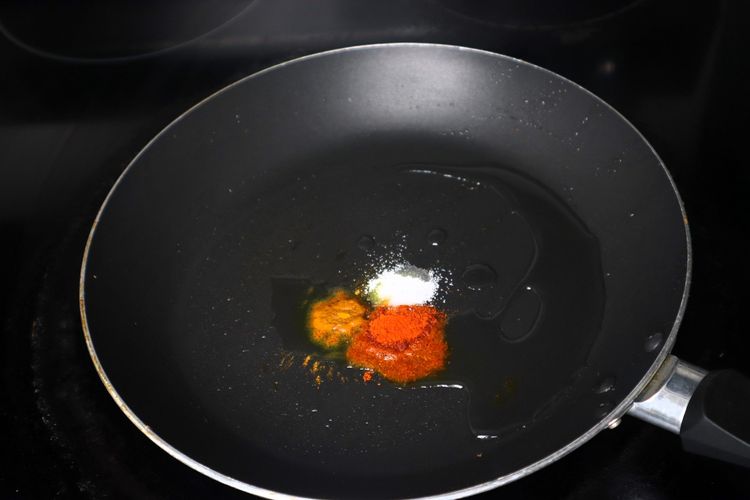 Step 2.5: In the same pan, add 1 tsp oil, turmeric powder, red chilli powder, and salt