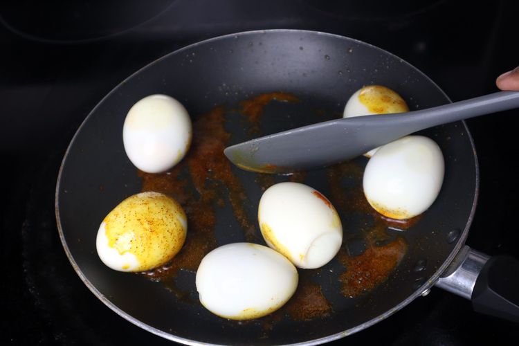 Step 2.2: Add boiled eggs and roast for 2 minutes until golden spots appear on the eggs