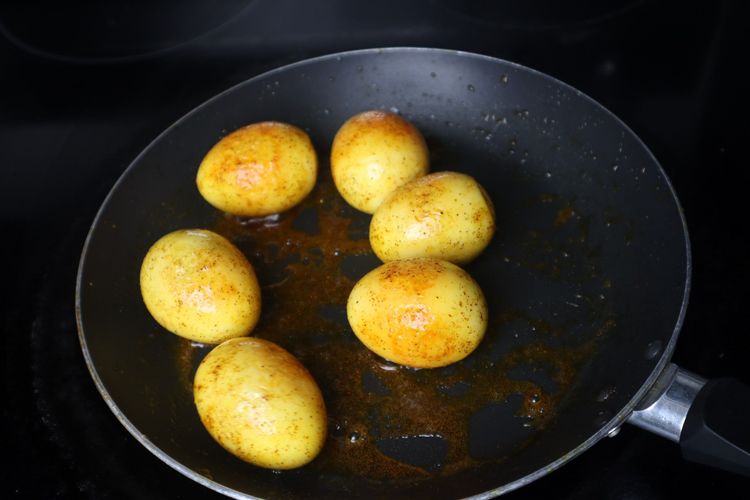 Step 2.3: Add boiled eggs and roast for 2 minutes until golden spots appear on the eggs