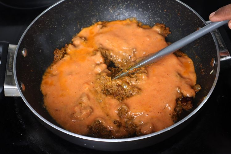 Step 2.2: Add tomato puree and sauté until oil separates