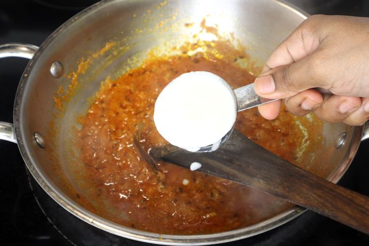 Step 2.1: Lower the flame, add curd, and cook until the oil separates again
